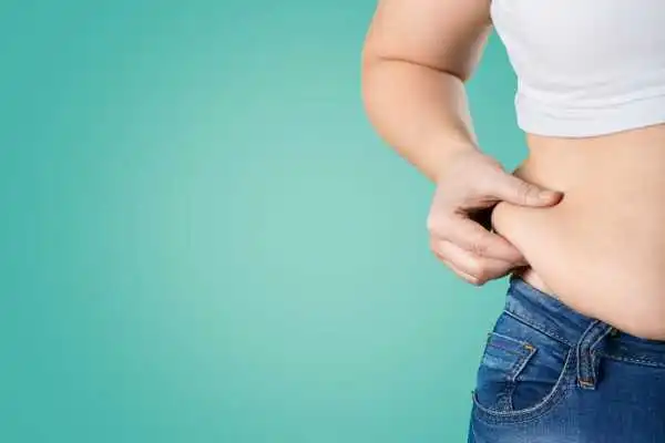 Image of woman pinching her love handles to show weight gain Willenhall